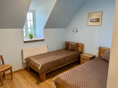 a small room with two beds and a window at Pakėvio dvaras - Pakevis manor in Kelmė