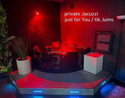 a red bathroom with a tub with a sign on the wall at Jacuzzi Cinema Loft in Kaunas