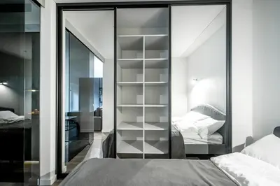 a bedroom with a glass partition with a bed at Jacuzzi Cinema Loft in Kaunas