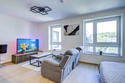 a living room with a couch and a tv at Kaunas City Center Deluxe in Kaunas