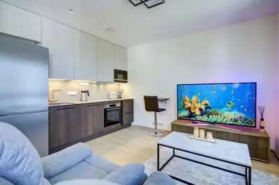 a living room with a blue couch and a large aquarium at Kaunas City Center Deluxe in Kaunas