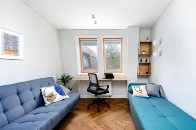a living room with a blue couch and a desk at V33 cozy apartment in Druskininkai