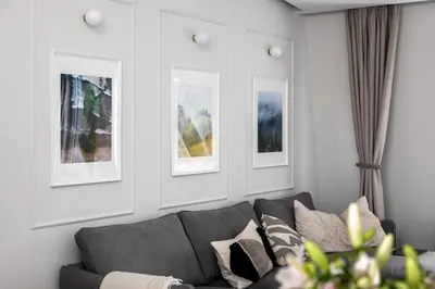 a living room with a couch and three pictures on the wall at V33 cozy apartment in Druskininkai