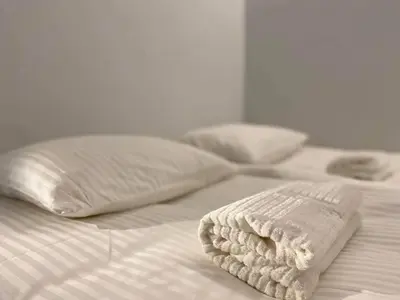 two beds with white sheets and pillows on them at Vytautas Park Apartment with FREE Parking in Marijampolė