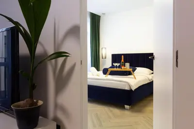 a bedroom with a bed and a potted plant at cohost I OldTown 60m2 APT w-Garage Parking, Balcony & Self Check-in in Vilnius