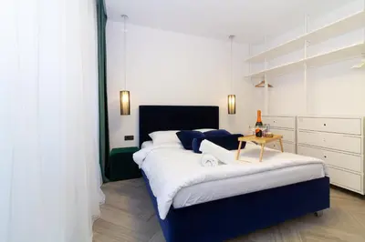 a bedroom with a large bed with a table on it at cohost I OldTown 60m2 APT w-Garage Parking, Balcony & Self Check-in in Vilnius