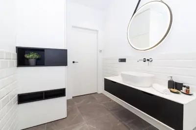 a white bathroom with a sink and a mirror at cohost I OldTown 60m2 APT w-Garage Parking, Balcony & Self Check-in in Vilnius