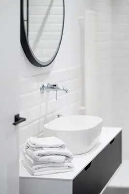 a white bathroom with a sink and a mirror at cohost I OldTown 60m2 APT w-Garage Parking, Balcony & Self Check-in in Vilnius