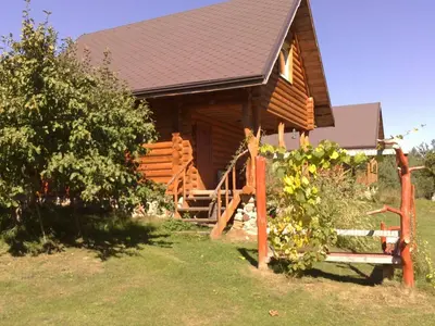 a log cabin with a bench in front of it at Likimo ratas in Paliepis