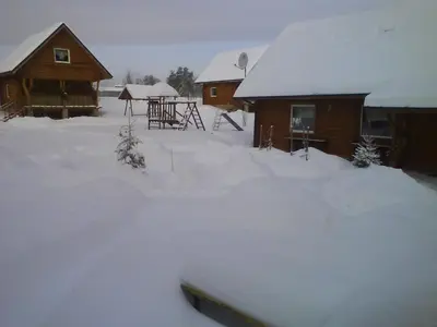 a yard covered in snow next to a house at Likimo ratas in Paliepis