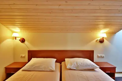 a bedroom with two beds and two lights on the wall at Vingis in Marijampolė