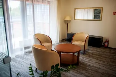 a waiting room with chairs and a table and a mirror at Vingis in Marijampolė