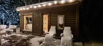 a cabin covered in snow with lights on it at Žuvininkų pirtelė in Šiauliai
