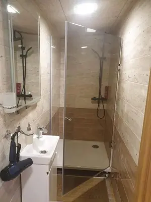 a bathroom with a shower and a sink at Žuvininkų pirtelė in Šiauliai