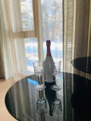 a bottle of wine and two glasses on a table at Greenwood apartments in Druskininkai