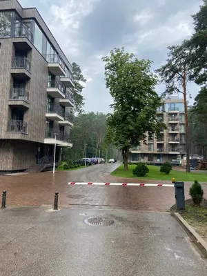 a street with a parking lot with a building at Greenwood apartments in Druskininkai