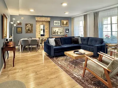 a living room with a blue couch and a table at Uzupis Deluxe Retreat in Old Town Vilnius in Vilnius