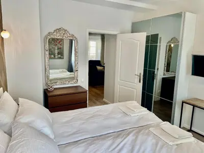 a bedroom with a white bed and a mirror at Uzupis Deluxe Retreat in Old Town Vilnius in Vilnius
