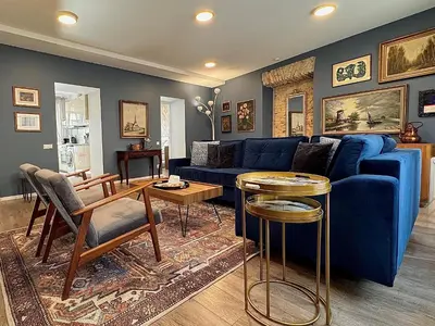 a living room with a blue couch and a table at Uzupis Deluxe Retreat in Old Town Vilnius in Vilnius