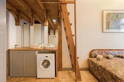 a washer and dryer in a room with a bed at Cozy studio and standard apartments in the heart of Oldtown in Vilnius