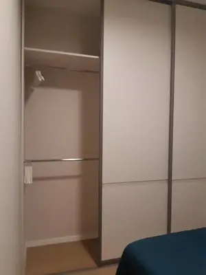 a closet with white cabinets and a blue bed at Apartment in Druskininkai City Centre in Druskininkai