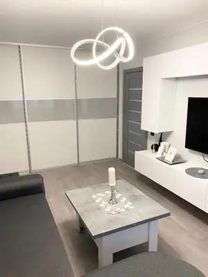 a living room with a table and a chandelier at Studio flat in Panevezys in Panevėžys