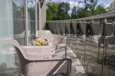 a porch with chairs and a vase of flowers on it at Apartment DoMiSol in Druskininkai
