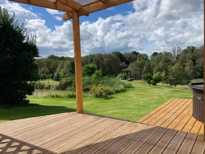a wooden deck with a gazebo in a yard at Molynė in Kaulakiai