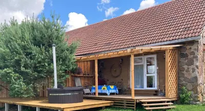 a cottage with a deck and a house at Molynė in Kaulakiai