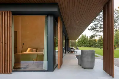 a bedroom is seen from the outside of a house at The Lake - Waterfront Villas Retreat in Mindūnai