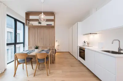 a kitchen with a table and chairs and a sink at cohost I NEW Apartment w-balcony, Self check-in at the Renesanso Complex in Vilnius