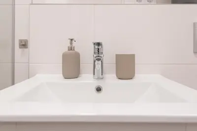 a bathroom sink with two soap dispensers on it at cohost I NEW Apartment w-balcony, Self check-in at the Renesanso Complex in Vilnius