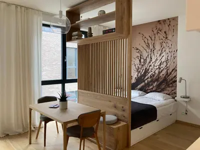a bedroom with a bed and a desk and a table at cohost I NEW Apartment w-balcony, Self check-in at the Renesanso Complex in Vilnius