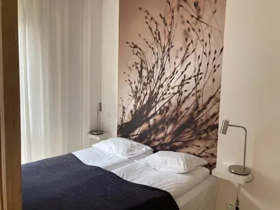 a bedroom with a bed with a painting on the wall at cohost I NEW Apartment w-balcony, Self check-in at the Renesanso Complex in Vilnius