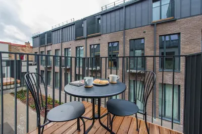a table on a balcony with two chairs and coffee cups at cohost I NEW Apartment w-balcony, Self check-in at the Renesanso Complex in Vilnius