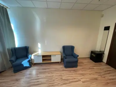 two blue chairs and a table in a room at Mr Jo’s hostel in Kaunas