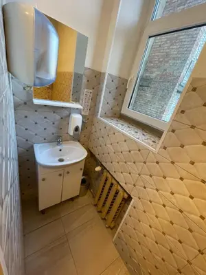 a small bathroom with a sink and a window at Mr Jo’s hostel in Kaunas