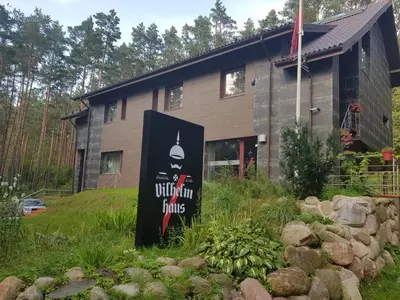 a building with a sign in front of it at Vilhelmhaus in Dėdeliškės