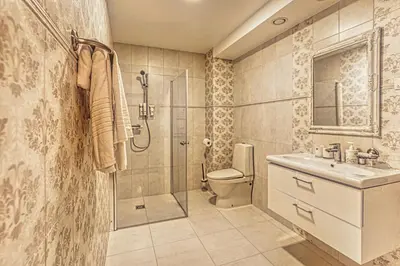 a bathroom with a shower and a toilet and a sink at Vilhelmhaus in Dėdeliškės
