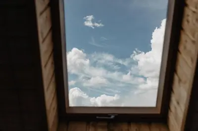 a window view of a blue sky with clouds at Vienkiemio Oazė - Namelis Prie Upelio in Galvokai