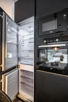 an empty refrigerator with its door open in a kitchen at Botanical Garden Loft in Kaunas