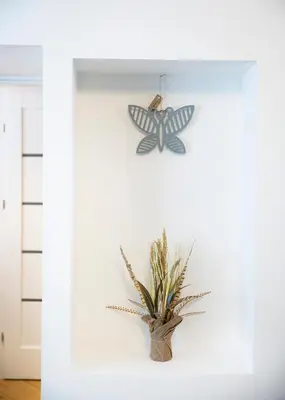 a potted plant and a butterfly on a wall at Groundfloor Apartment on the Green Hill in Kaunas