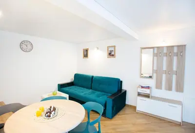 a living room with a blue couch and a table at Groundfloor Apartment on the Green Hill in Kaunas