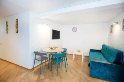 a living room with a couch and a table and chairs at Groundfloor Apartment on the Green Hill in Kaunas