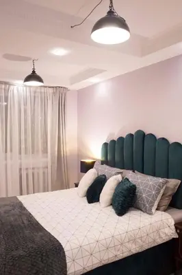 a bedroom with a large bed with a blue headboard at Siauliai Apartments - Lieporiu in Šiauliai