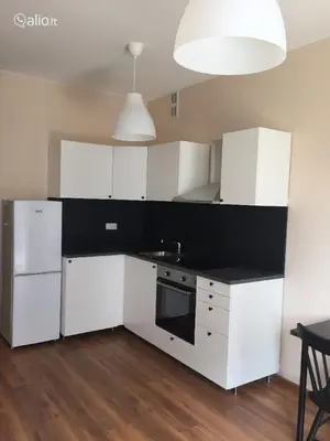 a kitchen with white cabinets and a black counter top at Close to PANORAMA center apartment Self check-in Garage free in Vilnius