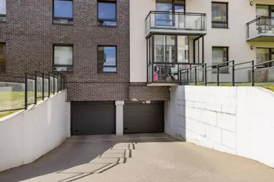 a brick building with a parking garage in front of it at Close to PANORAMA center apartment Self check-in Garage free in Vilnius