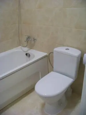 a bathroom with a white toilet and a bath tub at Close to PANORAMA center apartment Self check-in Garage free in Vilnius