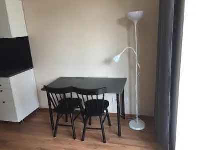 a black table with two chairs and a lamp at Close to PANORAMA center apartment Self check-in Garage free in Vilnius