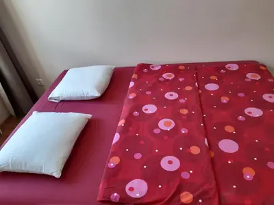 a red bed with polka dot sheets and pillows at Close to PANORAMA center apartment Self check-in Garage free in Vilnius